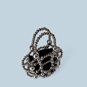 Detail of silver beaded handbag with metallic beads and contrasting black fabric lining