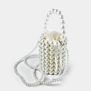 Close-up of handmade pearl bucket bag featuring gold metal beads and satin drawstring liner