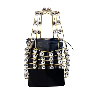 Detail of gold metal hollow frame bag with silver beads and black drawstring inner pouch