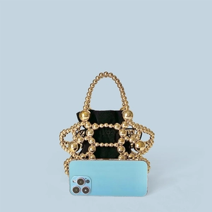 Detail of handmade gold beaded hollow handbag with inner pouch and mobile phone for size comparison