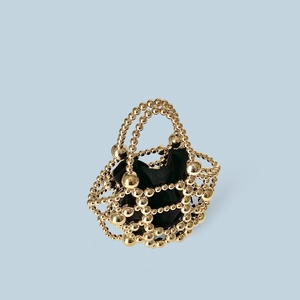 Detail of golden beaded evening bag with hollow geometric structure and black inner pouch