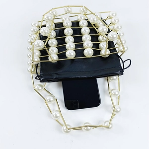 Top view of hollow metal cage handbag with pearls showing smartphone capacity detail