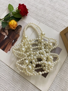 Detailed close-up of the woven imitation pearl handbag featuring layered beads and floral decor
