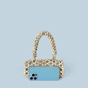 Mini sac à main perlé à motif marbre à côté d'un smartphone pour la taille