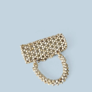 Détail d'un sac à main fait main en perles marbrées avec des anneaux métalliques dorés
