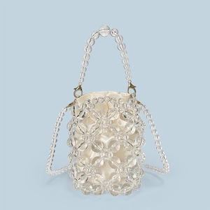 Detail of beaded acrylic bucket bag featuring woven crystals and champagne satin inner bag