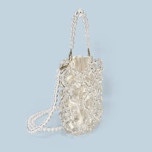 Close-up of beaded bucket bag with clear acrylic beads and white satin drawstring pouch