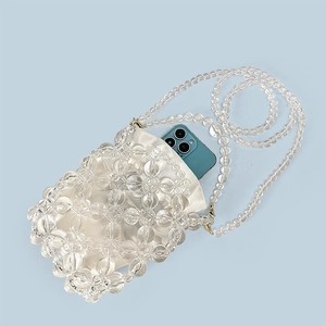 Detail of beaded crossbody phone bag with satin drawstring pouch and blue phone for scale
