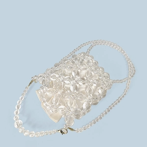 Detailed macro view of handmade acrylic beaded bag with a satin drawstring lining