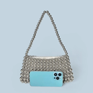 Silver beaded tote bag with trapezoid structure shown next to a smartphone for size reference