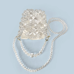Macro view of clear beaded acrylic bucket bag with cream satin drawstring lining