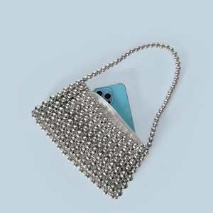 Silver beaded handbag detail showing interior space fitting a large smartphone