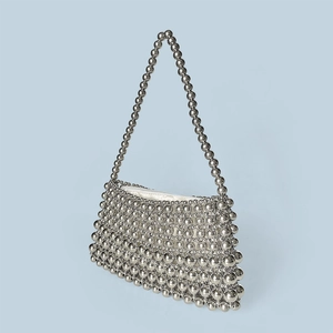 Macro detail of hand-woven silver metal beads and smooth white inner lining of the bag
