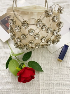 Close-up of elegant beaded evening bag with silver metal rings and crystal embellishments