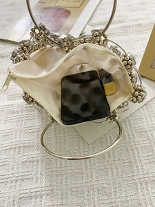 Detailed interior of luxury woven crystal evening bag with metal ring handles