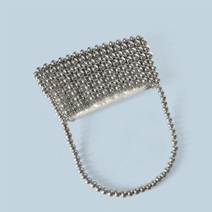 Macro detail of silver beaded handbag showing textured metal beads and zipper closure