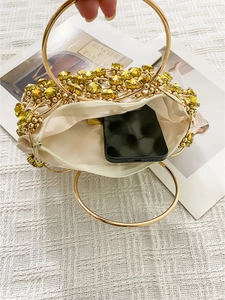 Detail view of the beaded clutch interior with satin lining and gold metal ring handles