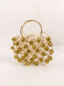 Detail of luxury evening bag with gold metal rings and olive green gemstones