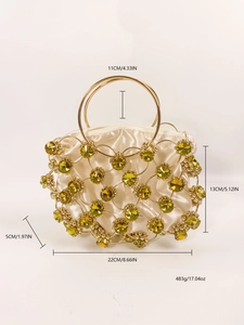 Detail of luxury evening handbag with golden metal grid and green gemstones