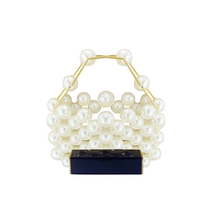 Detail of handmade beaded pearl handbag with gold metal handle and lipstick for scale
