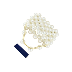 Close-up of elegant handmade beaded mini bag with white pearls and gold hardware