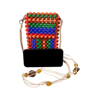 Close-up of handmade colorful beaded phone bag with woven strap and silver metal clasp