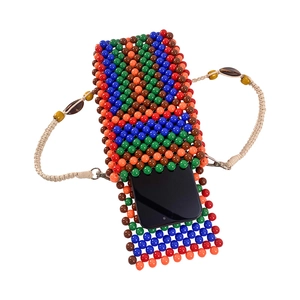 Detail of colorful handmade beaded phone bag with woven shoulder strap and wooden beads