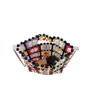 Detail view of colorful beaded crossbody bag showing inner capacity with a lipstick inside