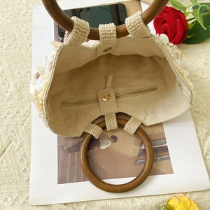 Détail du sac à main avec paillettes, poignée en bois et poche intérieure zippée