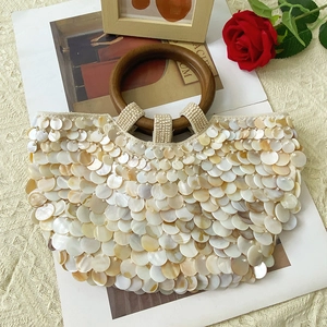 Détail de disques de nacre ivoire et de perles blanches sur un sac bohème chic