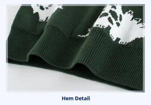 Detail of dark green knit sweater hem with white jacquard pattern and ribbed cuff finish