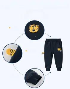 Détail du pantalon en coton bleu pour enfant avec broderie tigre et queue 3D