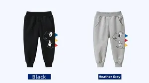 Détail de pantalons de jogging pour enfants en noir et gris avec décor dinosaure
