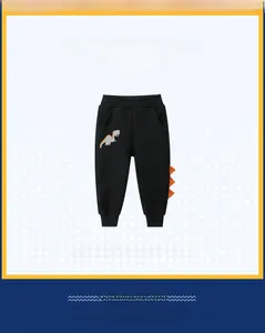 Detail of kids black joggers featuring dinosaur embroidery and orange spikes
