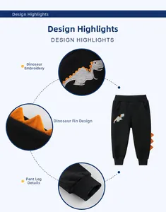 Detail of boys black joggers featuring orange dinosaur scales and embroidered patterns