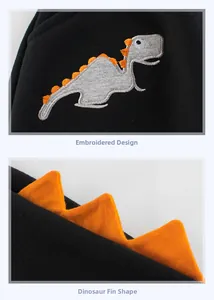 Detail of embroidered dinosaur pattern and 3D orange fins on kids black fleece pants