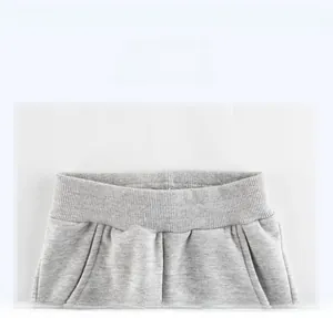 Detail view of the ribbed elastic waistband and side pockets on light gray cotton pants