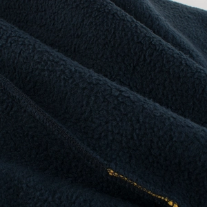 Gros plan du tissu polaire bleu marine avec coutures détaillées sur pantalon enfant