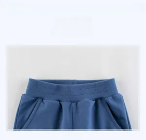 Détail de joggings bleus pour enfants avec taille élastique et poches latérales