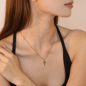 Delicate gold Ankh cross pendant necklace on a fine chain worn by a female model