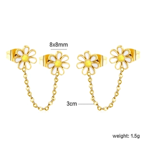 Detail van madeliefje oorbellen met wit emaille en een gouden schakelketting van 3cm