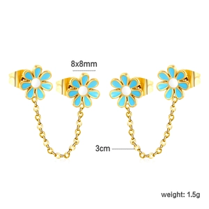 Detail van gouden madeliefje dubbele oorbellen met blauw emaille en lange schakelketting