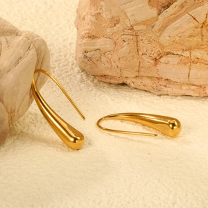 Vue détaillée de longues boucles d'oreilles dorées en goutte d'eau avec finition polie miroir
