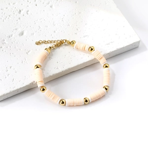 Bracciale bohémien con dischi heishi e perline dorate su una base in pietra naturale