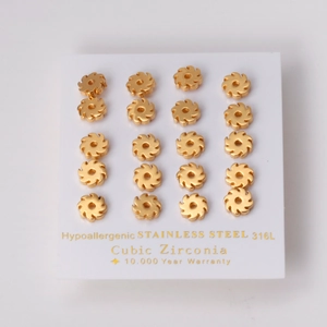 Golden flower earrings in 316L stainless steel with cubic zirconia on white card