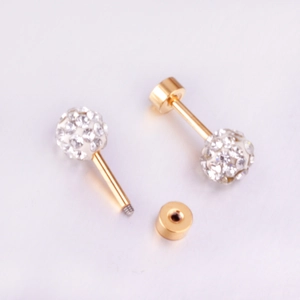 Détail macro de boucles d'oreilles boules dorées avec micro-pavage de cristaux blancs