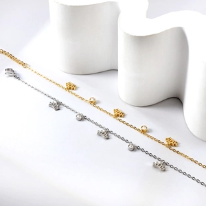 Détail des pendentifs couronne et breloques en cristal sur bracelets de cheville or et argent