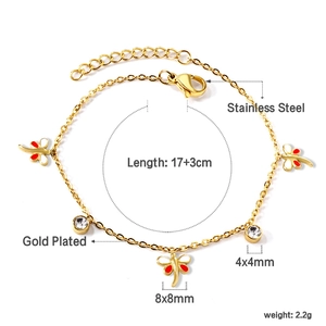 Détail des breloques libellules dorées et cristaux blancs sur le bracelet en acier