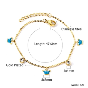 Détail du bracelet en acier inoxydable doré avec breloques couronne bleues et zircons blancs