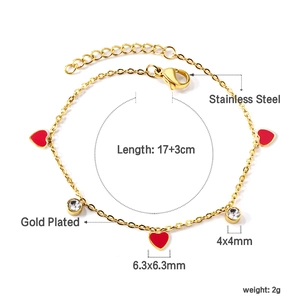 Détail du bracelet en acier inoxydable doré avec cœurs en émail rouge et zircons clairs